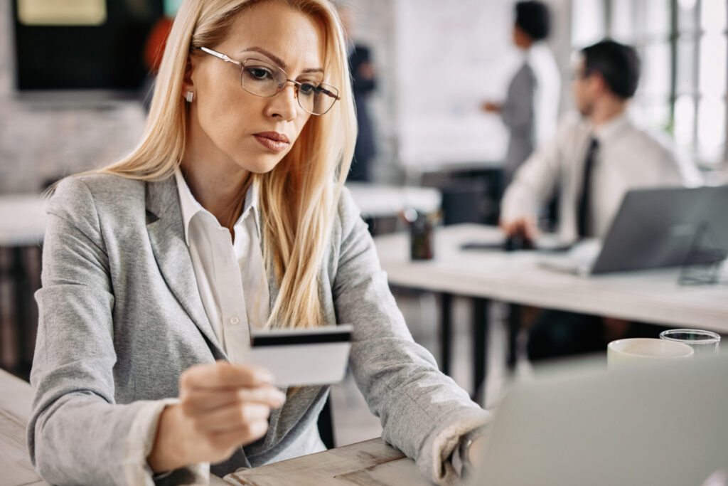 businesswoman holding credit card while using laptop and e banki
